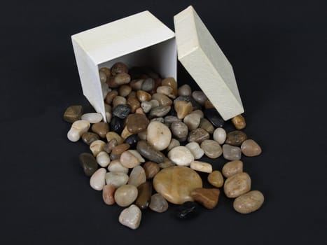 A box of nicely polished stones in a box isolated on a black background.