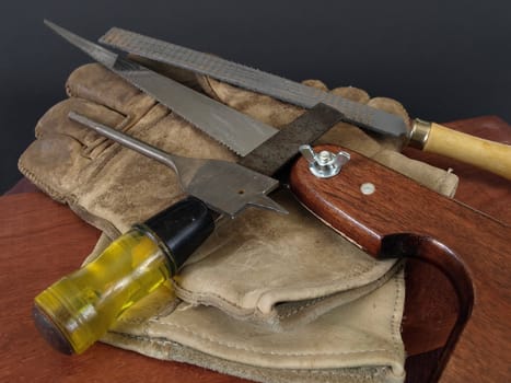 Small hand tools for woodworking, with a pair of leather gloves.