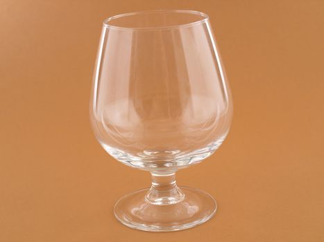 An empty glass isolated against a brown background.