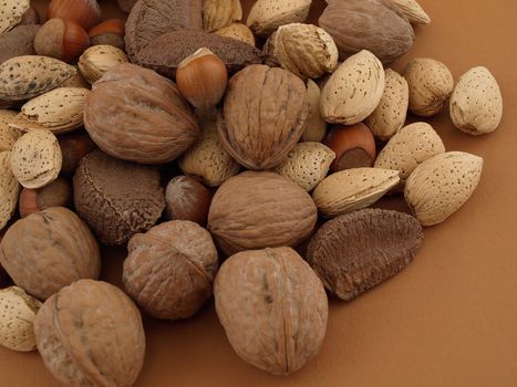 A selection of various types of nuts isolated on a brown background.