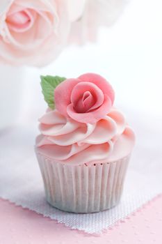 Cupcake decorated with a pink sugar rose