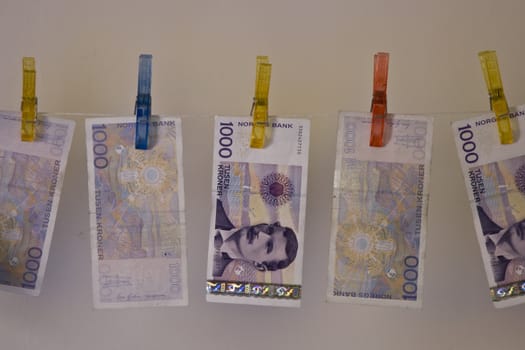 Illustration with the highest denomination of bank notes in Norway, hanging on a clothes hanger with clothes-pegs. Could illustrate money laundering and illegal business, but also a good illustration for wealth and money. 
