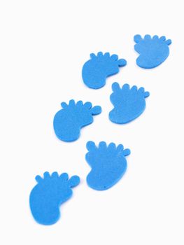 6 blue foam footprints in a trail isolated on a white back ground