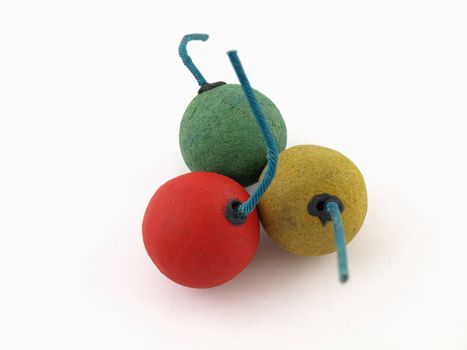 A cluster of a red, a green and a yellow smoke bomb isolated on a white background