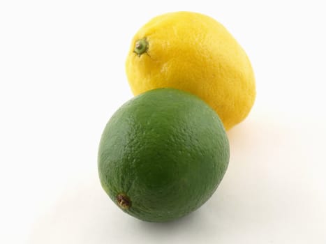 A green lime and a yellow lemon isolated on a white background