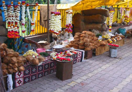 A street market in Chennai, India. They sell flowers and coconuts to worshippers to offer in a Hindu Temple behind the marketplace.

