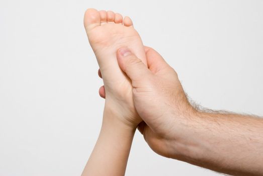 Children's foot in a man's hand. Massage