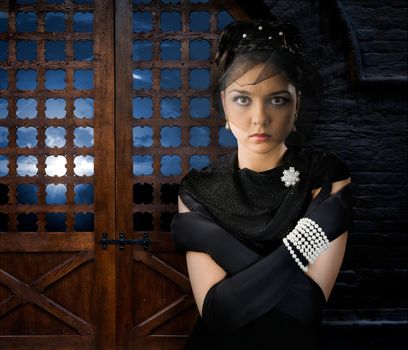 Woman on backdrop of antique wooden doors