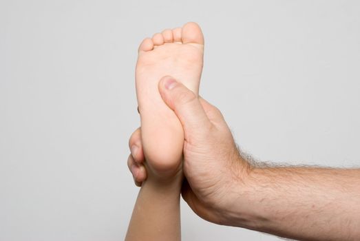 Children's foot in a man's hand. Massage