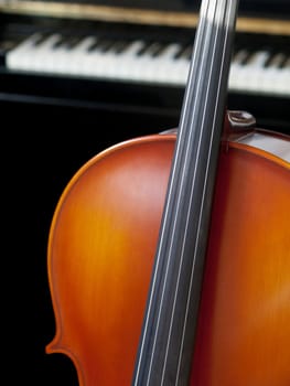 Cello standing in front on a piano
