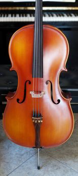 Panoramic view of a cello standing out in front of a piano