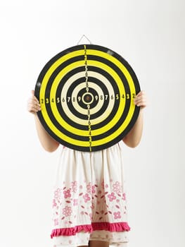 young girl holding target board covering her face