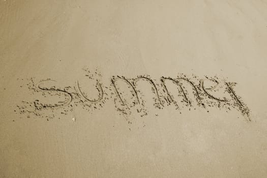 the word summer written in sand