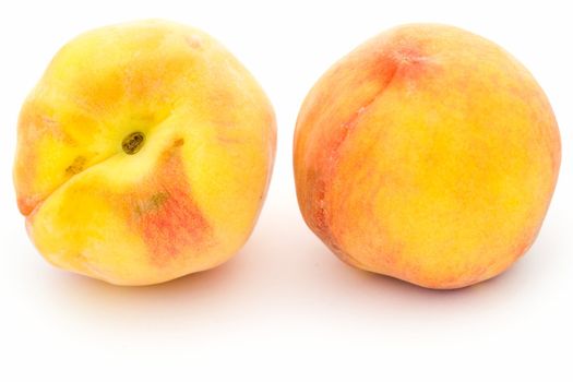 Two ripe peaches on a white background