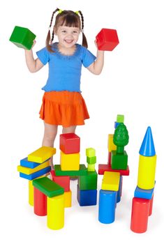 Cheerful girl playing with colored blocks on white