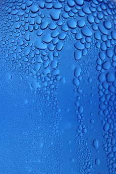 Drops of water clinging to a transparent blue surface