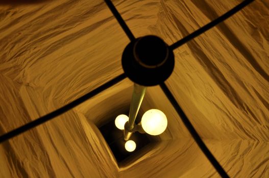 View from above into a paper lamp with 3 burning lightbulbs