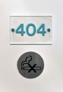 Number 404 on hotel room door plus non smoking sign