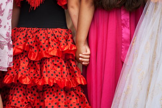 Two girlfriends ind red dress holding hands