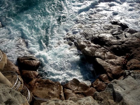 Close up of water splashing up against rocks. 