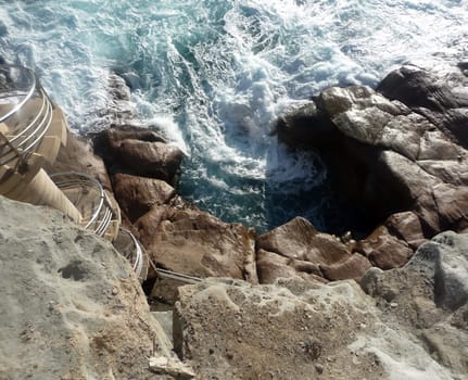 Close up of water splashing up against rocks. 