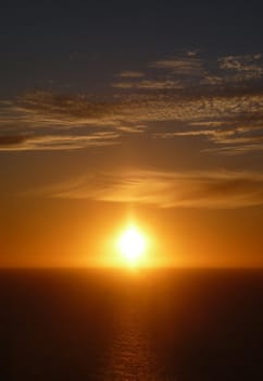 The sun setting over a ocean horizon.