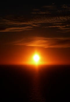 The sun setting over a ocean horizon.