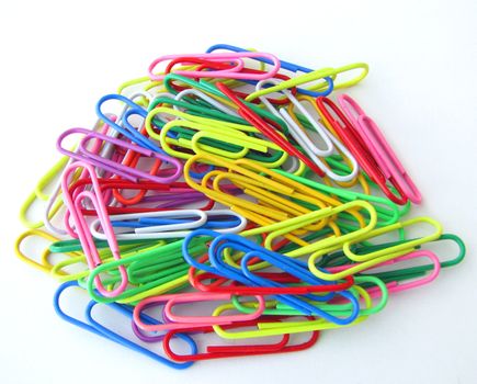 A chaotic pile of paper clips on white background.

