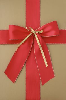 Close-up of a classic giftbox in gold and with a red ribbon