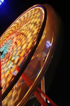 Motion blurred night shot of a ferris wheel at the fairground