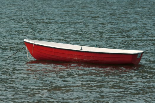 Empty red rowing boat on a fishing lake