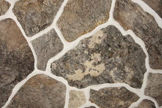 Detail from an old fashioned stone wall pattern with different sizes of stone - lit with studio strobes