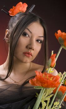 beautiful young asiatic girl with red poppies against red