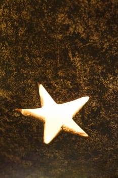 Close-up of decorative glowing star shape in metal lamp.