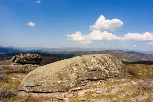 Landscape : View over rocky hills with blue sky and fluffy white clouds. Geres, Portugal.