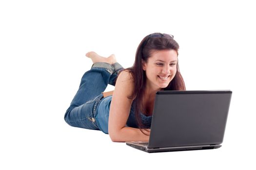 Beautiful brunette woman with brown hair smiling and laying down using a laptop computer. Isolated on white background.