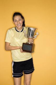 Portrait of Multi-racial teen girl holding trophy.