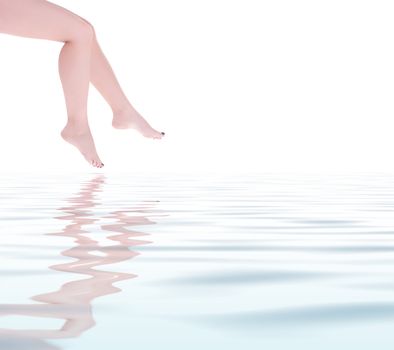 Beautiful woman legs reflected on clear water surface. Copy space, white background.