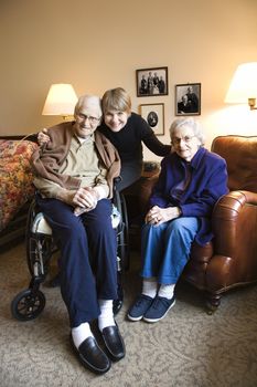 Caucasian middle-aged daughter with elderly parents in retirement community center.