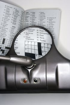 Vision magnifying glass used to view crossword puzzle.