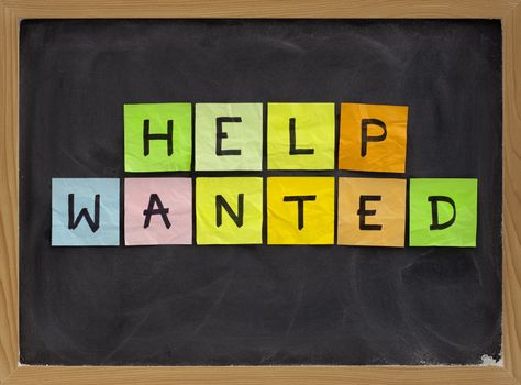 help wanted - colorful sticky notes sign on blackboard with white chalk texture