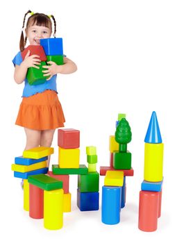 Happy child builds a castle out of color blocks