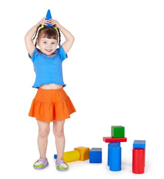 Little girl is playing with colored blocks on a white background