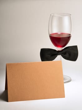red wine glass with bowtie and blank card