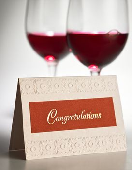 congratulation card in front of the red wine glass