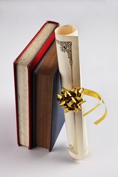 Diploma and books on the plain background