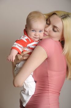 Young happy mother with boy baby in red t-shorts