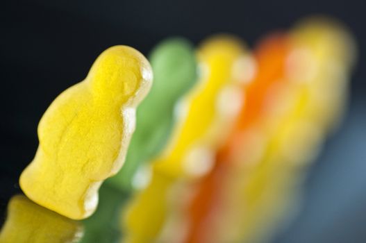 Line of jelly bears with dark background.