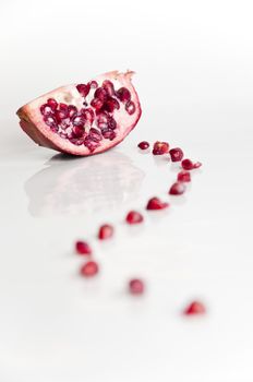 Pomegranate on white background with line of seeds