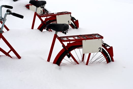 Red bicycles in deep snow on a winter day